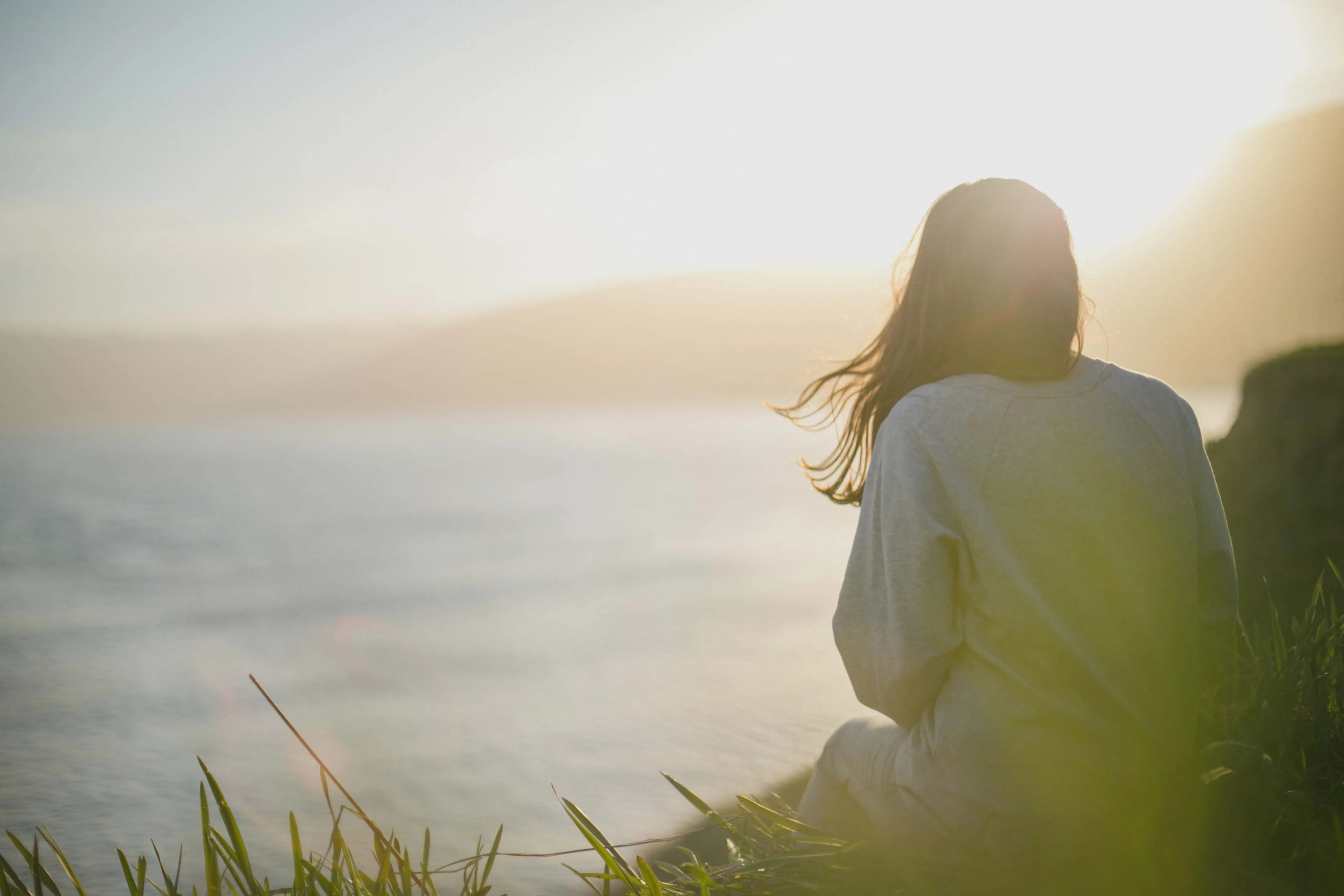 Person looking out at sunset representing nervous system regulation